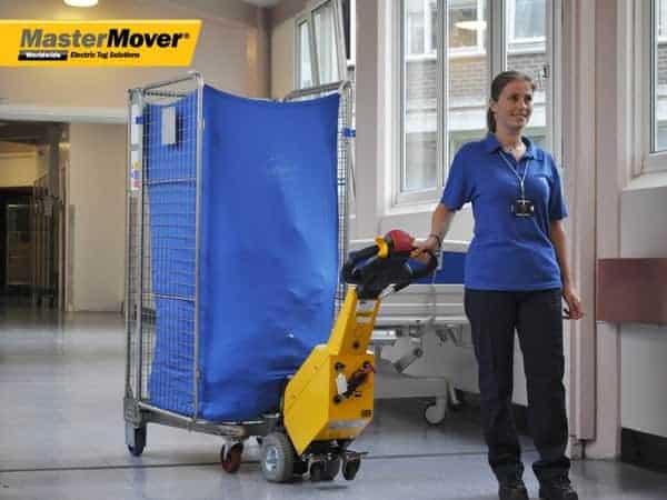 A-Healthcare-working-using-a-SM100-Electric-Tug-to-pull-a-Roll-Cage